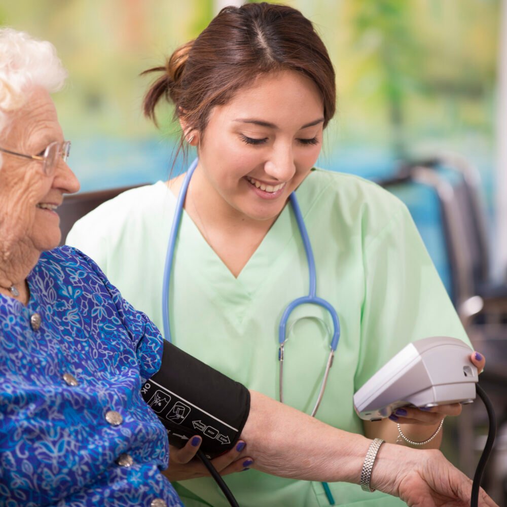 Home healthcare nurse checks blood pressure of elderly woman.